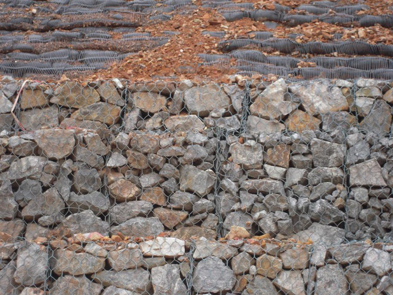 石籠網(wǎng)擋土墻，是石籠網(wǎng)籠子層疊堆砌的擋土建筑物